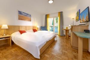 a bedroom with a large white bed and a desk at Hotel-Bio Gasthaus Am Felsenkeller in Staufen im Breisgau