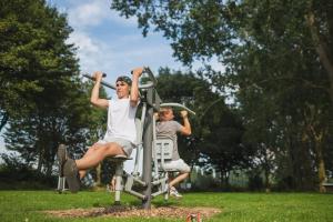 two people exercising on a exercise machine in a park at Recreatiepark Riverside in Appeltern