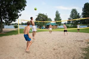 a group of young men playing a game of volleyball at Recreatiepark Riverside in Appeltern