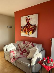 una sala de estar con sofá y una pintura en la pared en Le nid des Pruniers - F2 au calme - parking privé, en Sélestat