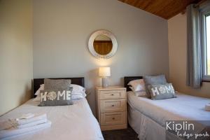 2 camas individuales en un dormitorio con espejo en Surrey Lodge en Richmond
