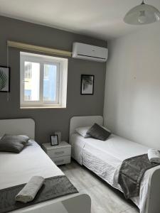 - une chambre avec 2 lits et une fenêtre dans l'établissement F3 Modern and Bright Apartment in Malta, à Msida