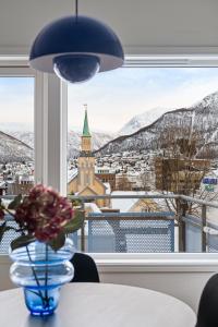 a vase of flowers on a table with a view at Downtown Apartment - THE VIEW in Tromsø