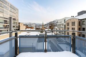 a balcony with a view of a city in the snow at Downtown Apartment - THE VIEW in Tromsø