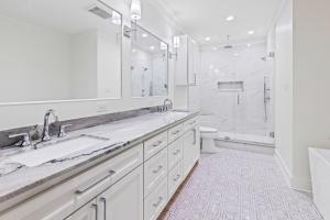 a white bathroom with two sinks and a shower at The Boating, Fishing, and Gaming Retreat in Hackberry