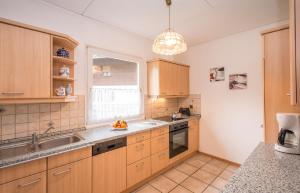 a kitchen with wooden cabinets and a sink and a window at Komfort-Ferienhaus Alpspitz in Grainau