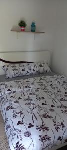 ein Bett mit einer schwarzen und weißen Bettdecke und Kissen in der Unterkunft Soba Tina in Vrdnik