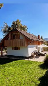 una casa bianca con tetto in legno e cortile di House-tanjevica a Kostanjevica na Krki
