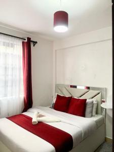 a bedroom with a large bed with red pillows at Rorot Spacious one bedroom in Kapsoya with free Wifi in Eldoret