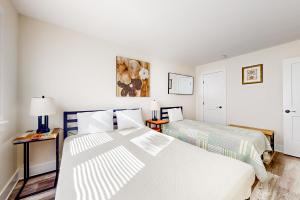 two beds in a room with white walls at Town of Rehoboth Beach --- 20485 Lincoln St. Unit 2 in Rehoboth Beach