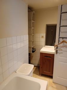 La salle de bains est pourvue d'une baignoire blanche et d'un lavabo. dans l'établissement Le cocon, à Gochenée