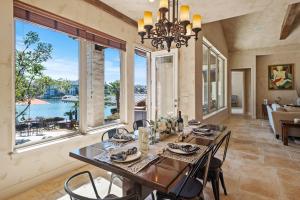 a dining room with a table and chairs and windows at Stunning Lakefront Retreat Pool Boat Lift Spectacular Views in Horseshoe Bay