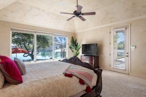 a bedroom with a bed and a ceiling fan at Stunning Lakefront Retreat Pool Boat Lift Spectacular Views in Horseshoe Bay +43 photos