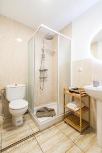 uma casa de banho com um chuveiro, um WC e um lavatório. em Home2Book Charming Apartments La Naval La Isleta em Las Palmas de Gran Canaria