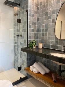 a bathroom with a sink and a shower with towels at Mana Beach Experience - 62m2 - 2 quartos - 1 Suite - com opcao de terreo tipo studio, 30m2 - Praia de Muro Alto in Porto De Galinhas
