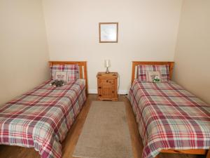 two beds sitting next to each other in a room at Llygad Yr Haul Sun in Burry Port