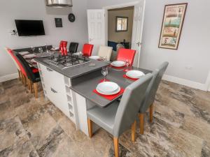 a kitchen and dining room with a table and chairs at Llygad Y Lleuad Moon in Burry Port