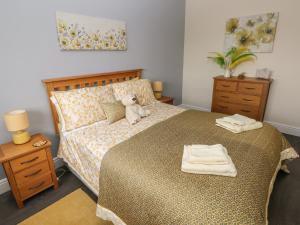 a bedroom with a bed with a teddy bear on it at Llygad Y Lleuad Moon in Burry Port