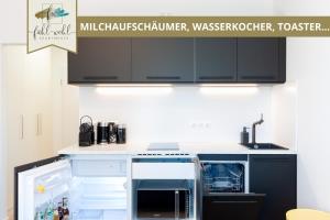 uma cozinha com armários pretos e um balcão branco em Apartment Wahnfried No4 - Zentral wohnen mit Küche und Duschbad, Parkplatz, 300m zur Fussgängerzone em Bayreuth