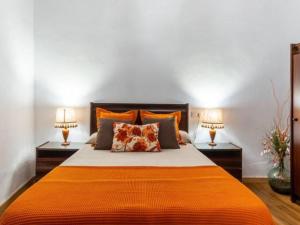 a bedroom with an orange bed with two lamps at Live Arico Casa Abuela in Arico el Nuevo