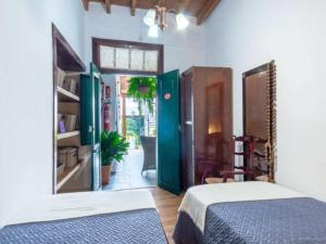 1 dormitorio con 1 cama y puerta que da a un patio en Live Arico Casa Abuela, en Arico el Nuevo