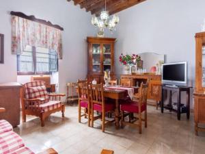 uma sala de jantar com uma mesa e cadeiras e uma televisão em Live Arico Casa Abuela em Arico el Nuevo