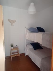 1 dormitorio con 2 camas y una mesa pequeña en Casa en la playa, Aldea Coast, en San Nicolás