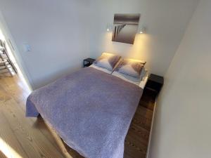 Un dormitorio con una cama con una manta morada. en Giljagisting, en Grafarkirkja