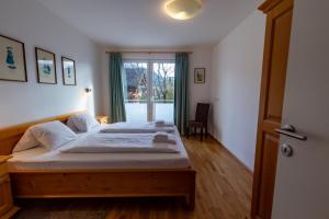 - une chambre avec un lit et une grande fenêtre dans l'établissement Pine Residence Zell am See - Steinbock Lodges, à Zell am See