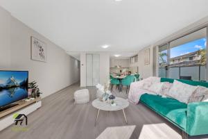 a living room with a green couch and a table at Entire apartment in Hornsby in Hornsby