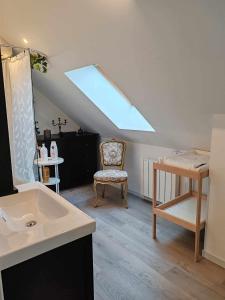 a bathroom with a sink and a chair in a attic at La Parenthèse Au Bain Nordique in Betton