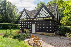 uma casa a preto e branco com uma cadeira no quintal em The Gatehouse at Samlesbury Hall em Samlesbury