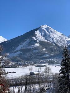 a snow covered mountain with a town in front of it at GS2 DUPLEX 4 PERS TERRASSE 5mn LUZ 15 mn ARDIDEN in Sassis +4 photos