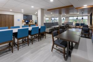 a dining room with tables and blue chairs at Holiday Inn Express Hotel & Suites Vineland Millville, an IHG Hotel in Vineland