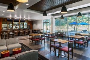 ein Restaurant mit Tischen und Stühlen und eine Bar in der Unterkunft Four Points by Sheraton at Phoenix Mesa Gateway Airport in Mesa