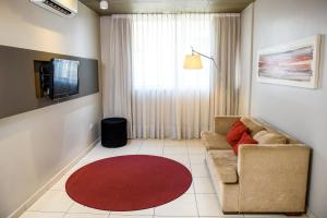 sala de estar con sofá y alfombra roja en Amérian Tucuman Apart & Suites en San Miguel de Tucumán