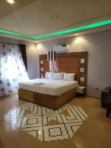 ein Schlafzimmer mit einem großen Bett und einem Teppich in der Unterkunft M View Hotel in Benin City