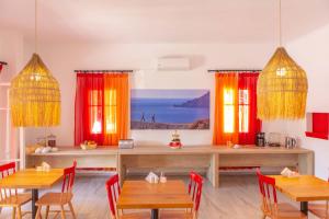 Acqua Vatos Paros Hotel في باريكيا: غرفة طعام مع طاولات وكراسي خشبية