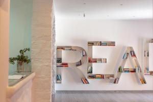 a room with shelves with books on them at Acqua Vatos Paros Hotel in Parikia