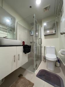 a bathroom with a shower and a toilet and a sink at Brenthill Baguio condo unit near SM baguio in Baguio