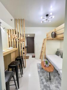 a room with a bed and a table and chairs at Brenthill Baguio condo unit near SM baguio in Baguio