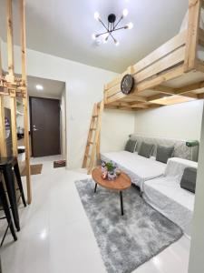 a room with a bed and a couch and a table at Brenthill Baguio condo unit near SM baguio in Baguio