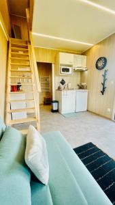 クロゾンにあるTiny house proche de Morgatのリビングルーム(ベッド1台付)、キッチンが備わります。