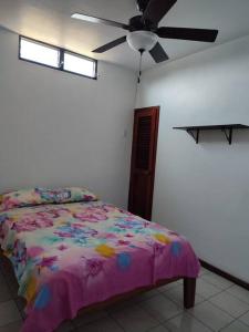 - une chambre avec un lit et un ventilateur de plafond dans l'établissement Alquiler de departamento independiente en Bahía de Caraquez, à Bahía de Caráquez