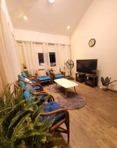 a living room with couches and a tv at Omma's Beach House in Lian