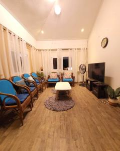 uma sala de estar com cadeiras, uma mesa e uma televisão em Omma's Beach House em Lian