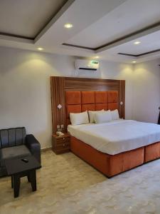 1 dormitorio con 1 cama grande y 1 silla en M View Hotel, en Benin City