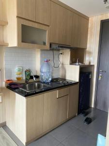 uma cozinha com um lavatório e um vaso no balcão em apartemen bintaro icon em Pondokaren