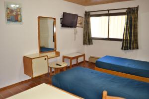 een kamer met 2 bedden en een spiegel bij Atenas para 2 personas in Las Lenas