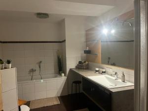 y baño con lavabo, bañera y espejo. en Ferienwohnung Defreggerhof en Winklern